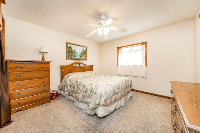 bedroom with ceiling fan, a textured ceiling, and light colored carpet