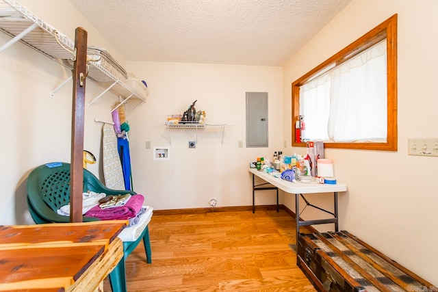 interior space featuring electric panel and light hardwood / wood-style flooring