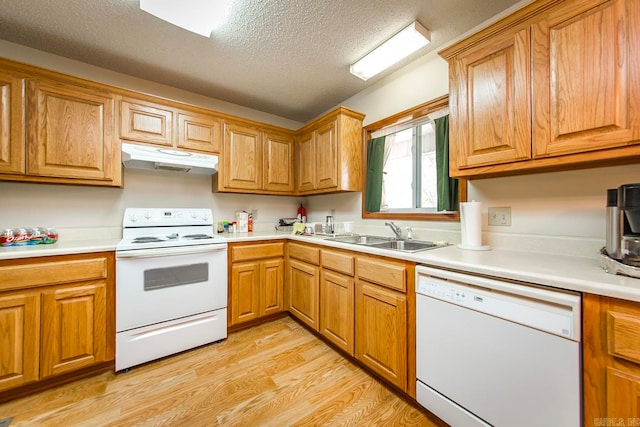 kitchen with white appliances, sink, a textured ceiling, and light hardwood / wood-style floors