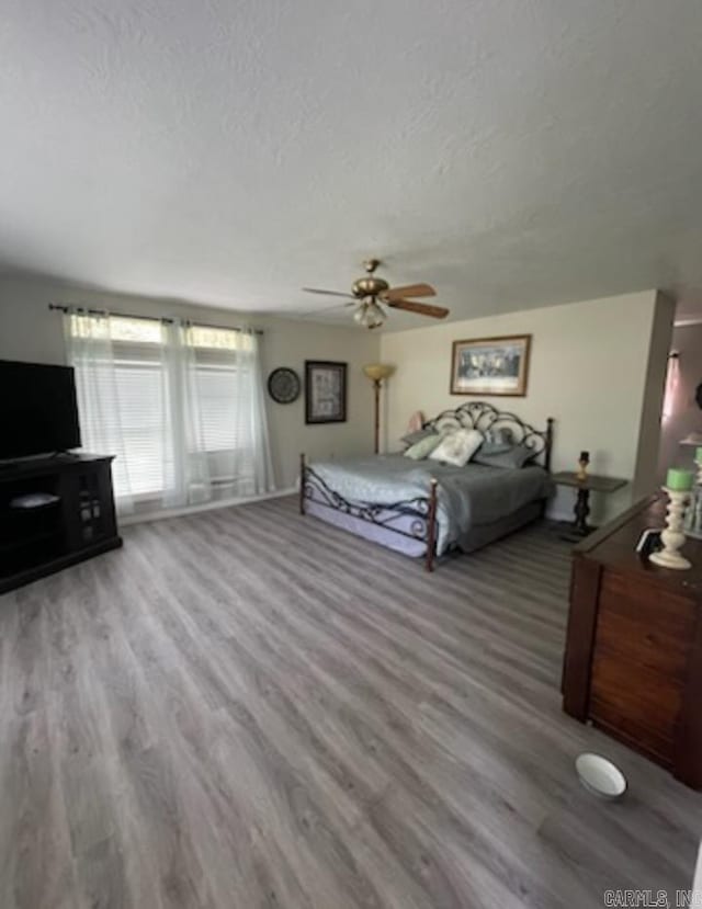 unfurnished bedroom featuring wood-type flooring, a textured ceiling, and ceiling fan