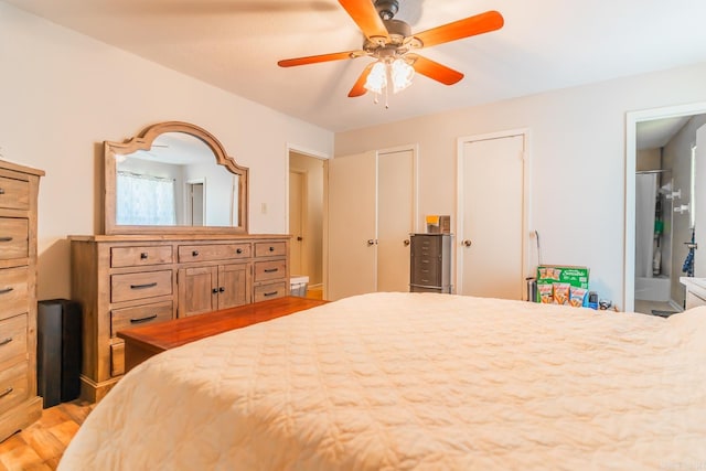 bedroom featuring wood-type flooring, multiple closets, and ceiling fan