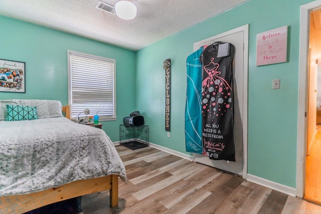 bedroom with hardwood / wood-style flooring and a textured ceiling