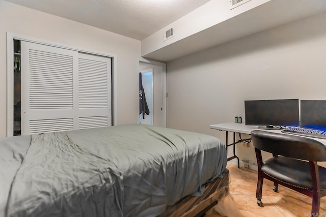 bedroom featuring a closet and light tile floors