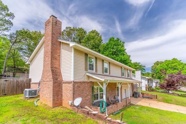 view of front of house featuring central AC unit and a front yard