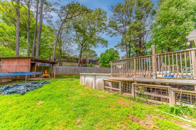 view of yard featuring a trampoline and a deck