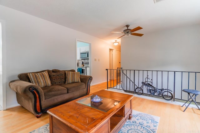 living room with light hardwood / wood-style flooring and ceiling fan