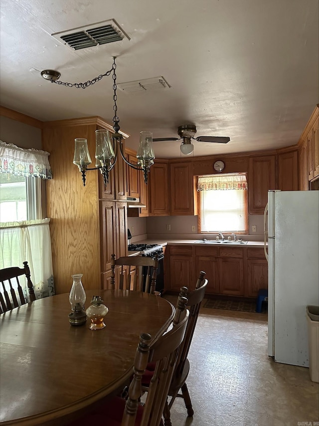 dining space featuring ceiling fan and sink