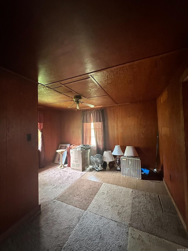 interior space featuring wood walls and ceiling fan