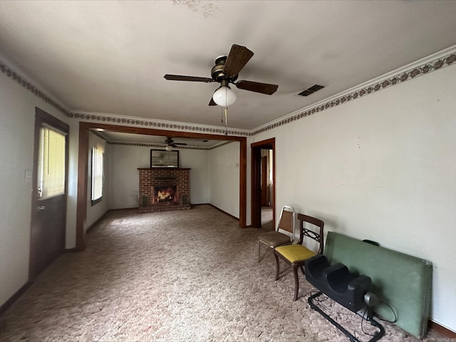 unfurnished living room with ornamental molding, ceiling fan, a fireplace, and carpet floors