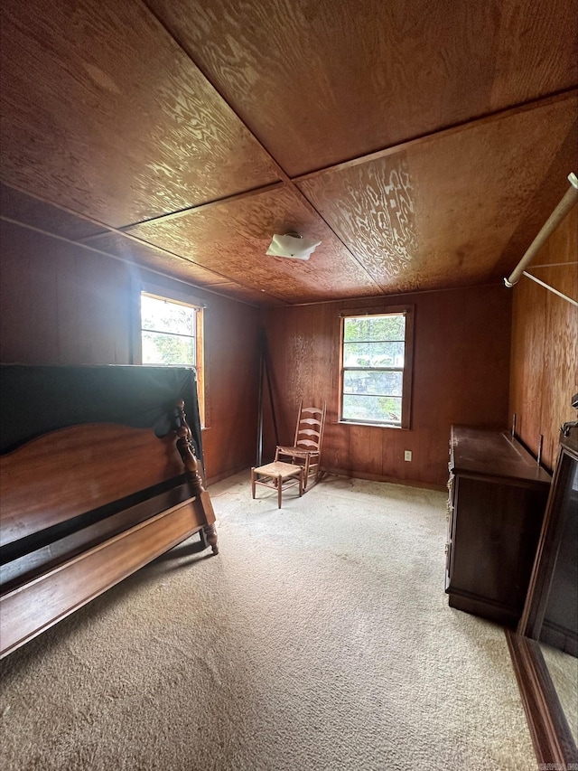 bedroom featuring light carpet, multiple windows, wood walls, and wood ceiling