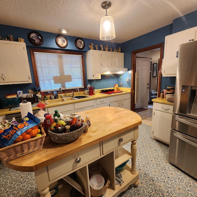 kitchen with white cabinetry, light tile flooring, stainless steel fridge with ice dispenser, and decorative light fixtures