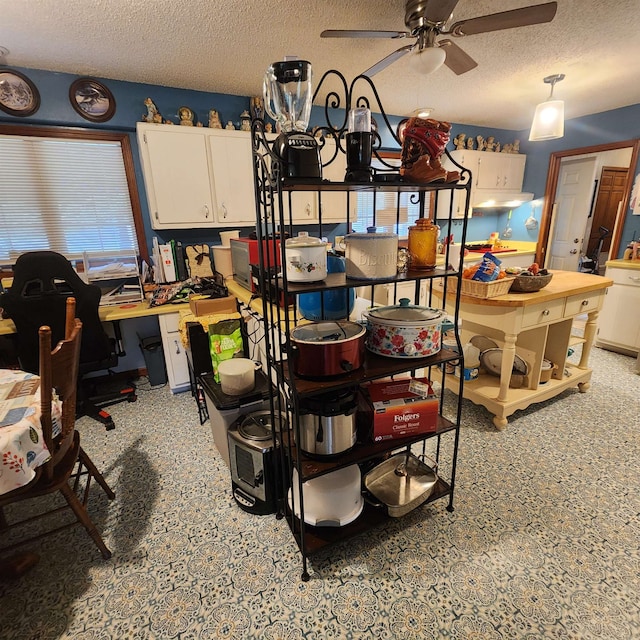 dining room featuring ceiling fan and a textured ceiling