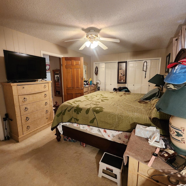 bedroom featuring light colored carpet, ceiling fan, and a textured ceiling