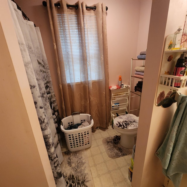 bathroom with tile flooring and toilet