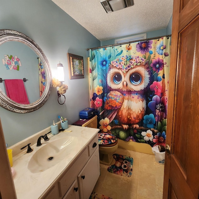 bathroom with toilet, tile flooring, a textured ceiling, and large vanity