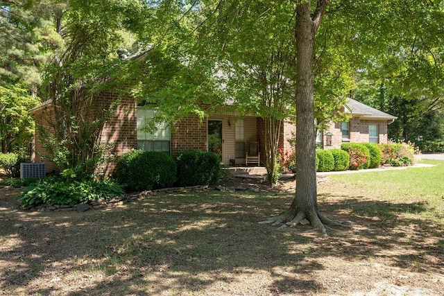 view of property hidden behind natural elements featuring a front yard