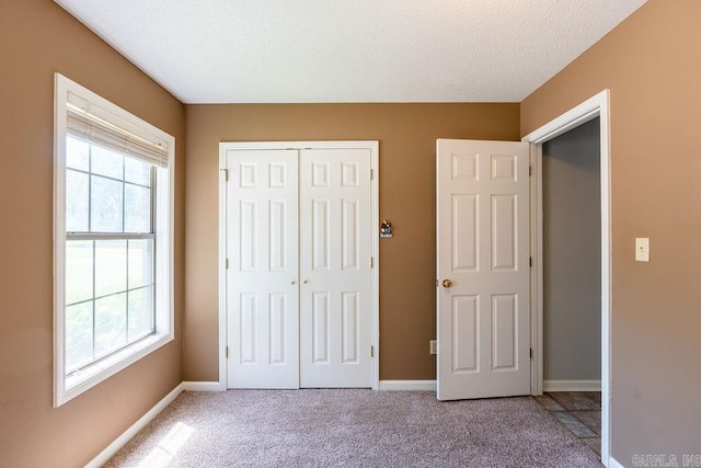 unfurnished bedroom featuring a closet, multiple windows, and carpet