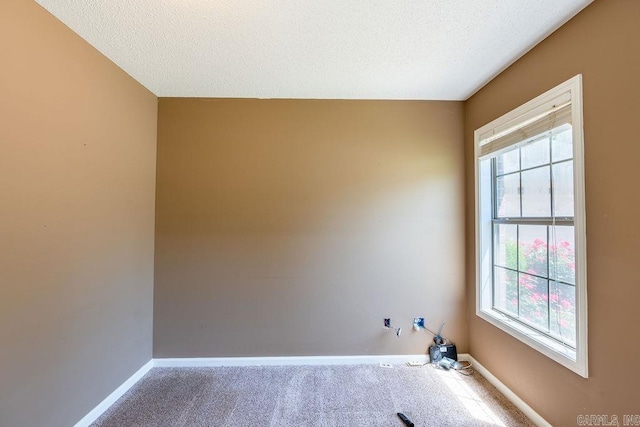 carpeted empty room featuring a textured ceiling