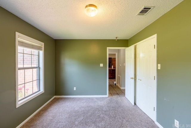 unfurnished room featuring a textured ceiling and carpet