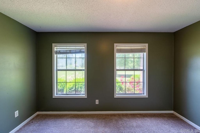 carpeted empty room featuring a textured ceiling