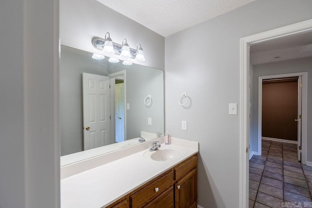 bathroom featuring tile flooring, oversized vanity, and a textured ceiling