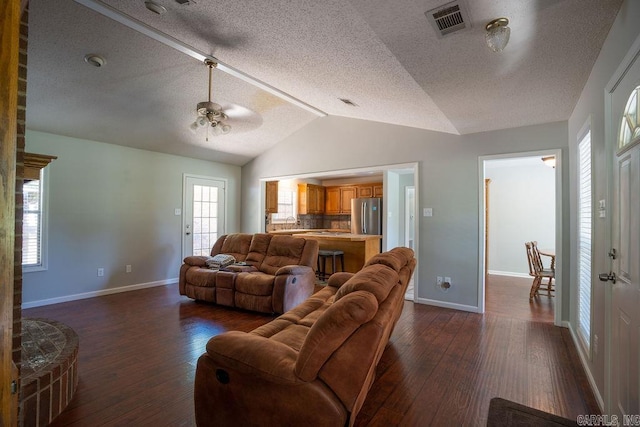 living room with lofted ceiling, ceiling fan, hardwood / wood-style flooring, and a textured ceiling