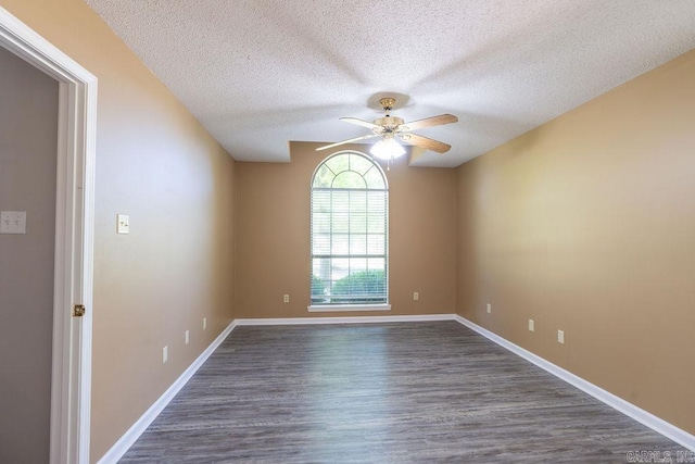 empty room with dark hardwood / wood-style floors, ceiling fan, and a textured ceiling