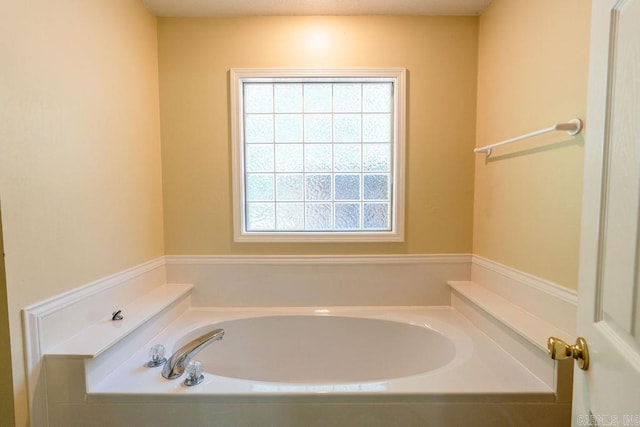 bathroom with plenty of natural light and a washtub