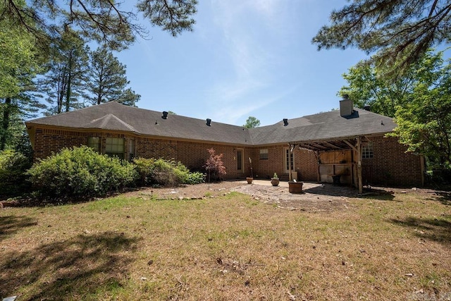 rear view of house with a patio and a yard