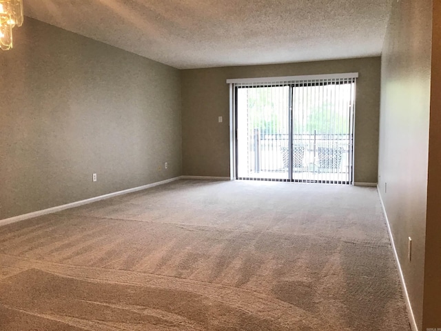 carpeted empty room featuring a textured ceiling