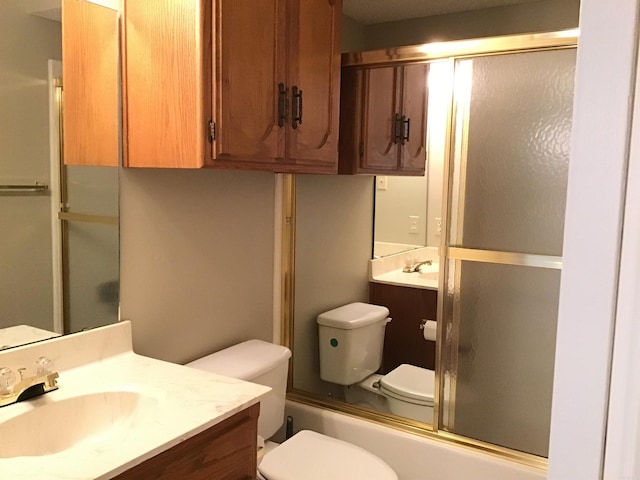 full bathroom with toilet, bath / shower combo with glass door, and vanity