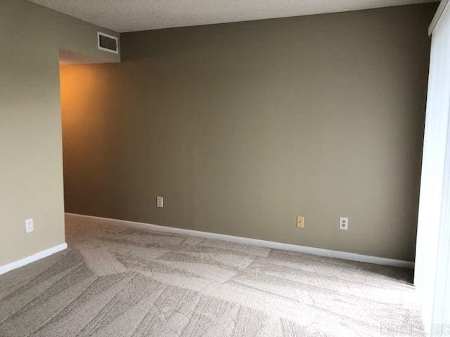 empty room featuring a textured ceiling and carpet floors