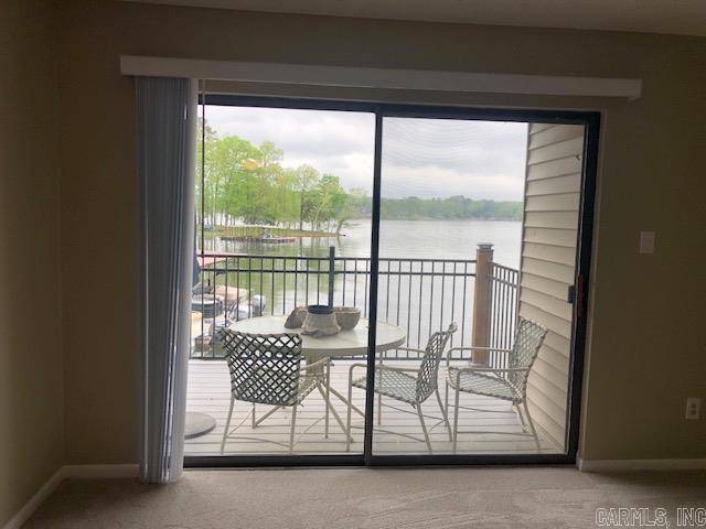 doorway to outside with carpet flooring and a water view