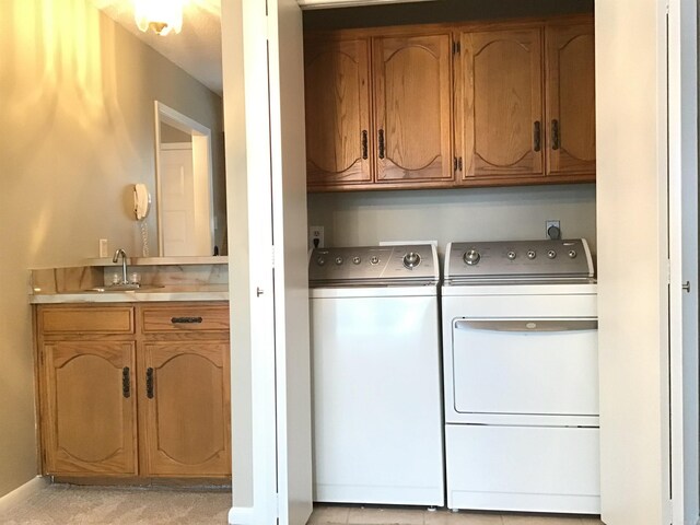 laundry area with hookup for an electric dryer, sink, cabinets, and washer and clothes dryer