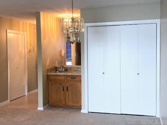 bedroom featuring a chandelier, light carpet, and sink