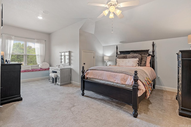 carpeted bedroom with ceiling fan and vaulted ceiling