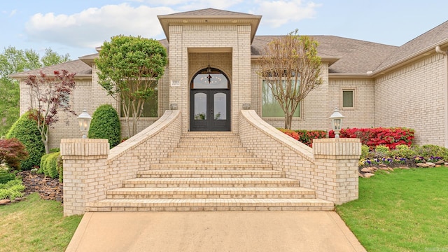 property entrance with french doors and a lawn