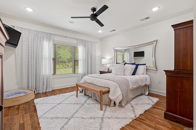 bedroom featuring hardwood / wood-style floors, ceiling fan, and ornamental molding