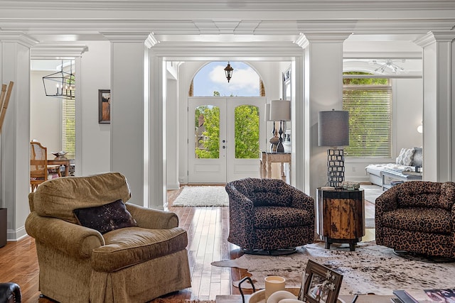 doorway with ornate columns, crown molding, and hardwood / wood-style flooring