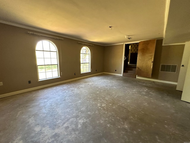 spare room with ornamental molding and concrete flooring