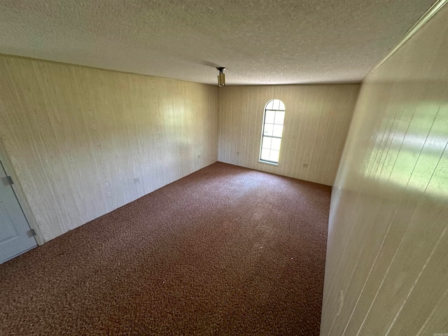 carpeted spare room with a textured ceiling