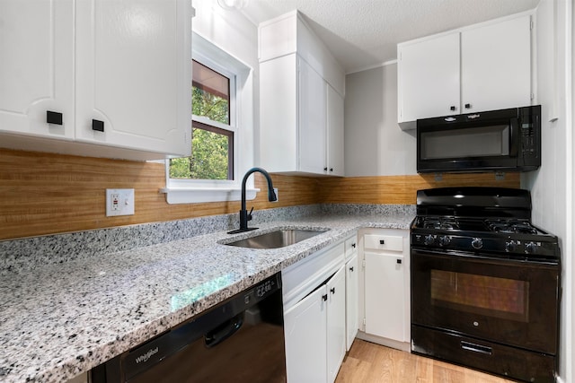 kitchen featuring white cabinets, light hardwood / wood-style flooring, sink, and black appliances