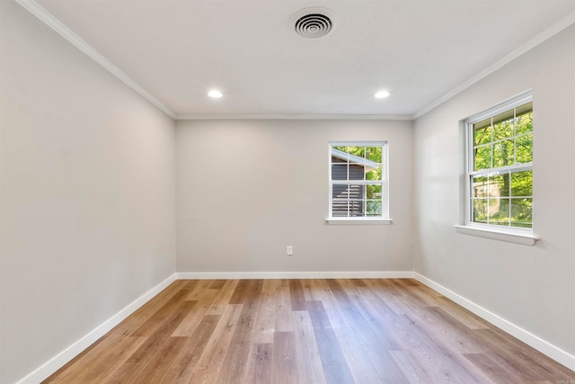 spare room with ornamental molding and light hardwood / wood-style floors