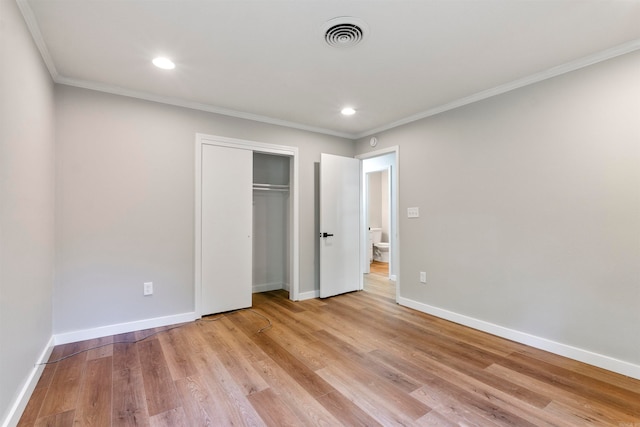 unfurnished bedroom with crown molding, light hardwood / wood-style flooring, and a closet