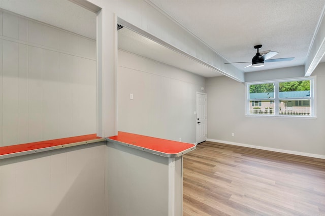 spare room featuring ceiling fan, a textured ceiling, and light wood-type flooring