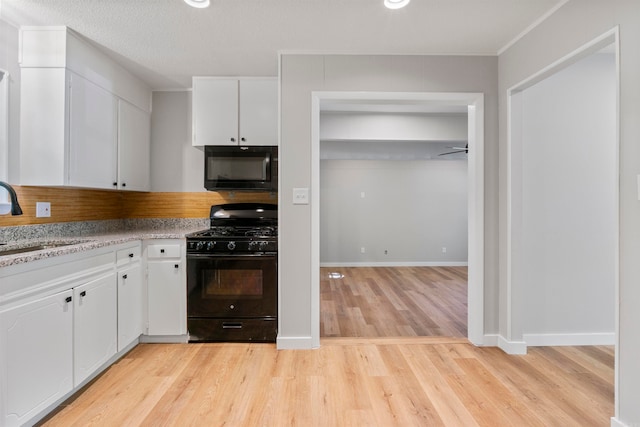 kitchen with white cabinets, sink, light hardwood / wood-style floors, and black appliances