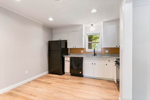 kitchen featuring white cabinets, sink, light wood-type flooring, and black appliances