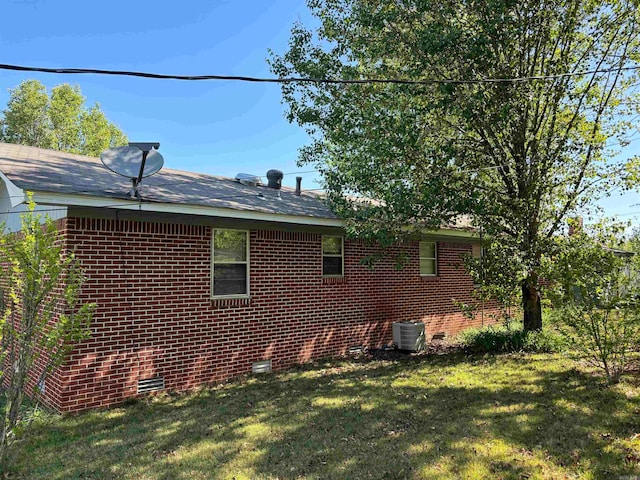 view of property exterior with a lawn and central AC unit