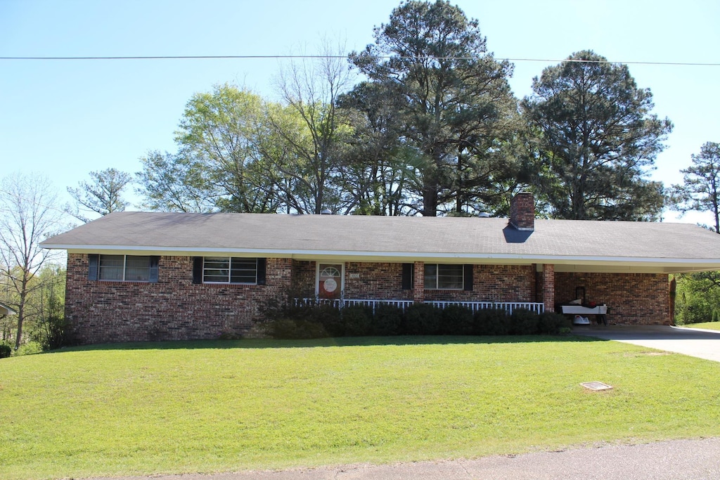 single story home featuring a carport and a front yard