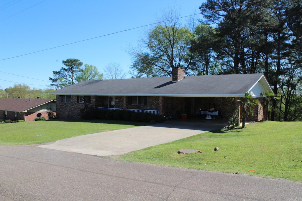 single story home featuring a carport and a front yard